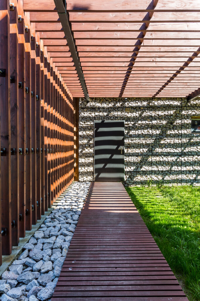 Minimalistyczna wiata samochodowa wykonana z drewna i metalu, zapewniająca ochronę przed warunkami atmosferycznymi. Nowoczesne rozwiązanie pasujące do współczesnej architektury.”
Wiata samochodowa z drewnianą konstrukcją